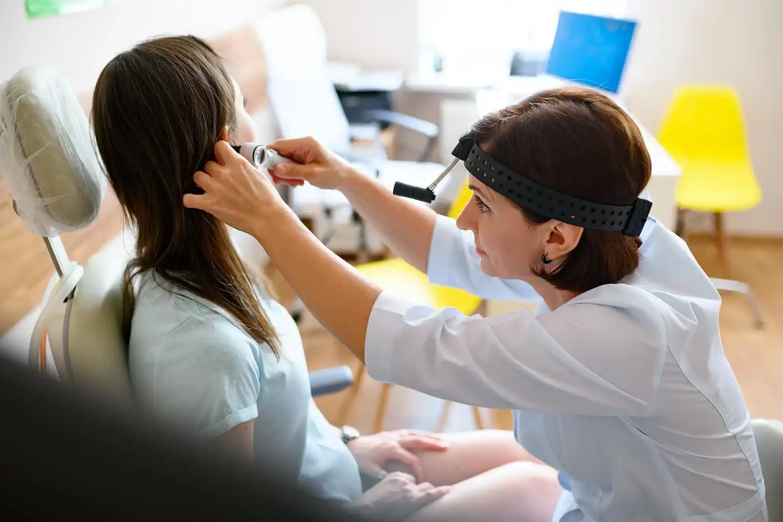 A healthcare professional performing a clinical examination in a modern medical office setting.