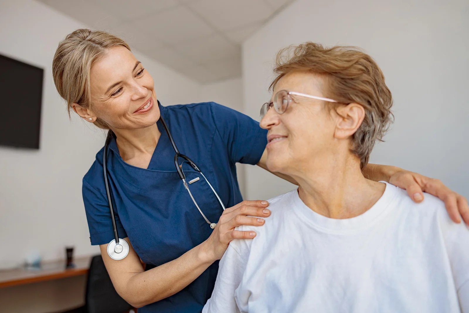 A medical professional provides compassionate support to a patient during an appointment.