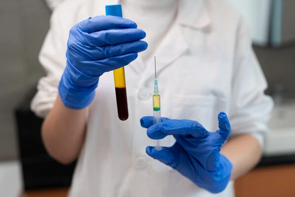 Medical professional holding a PRP blood sample tube and prepared injection syringe as part of the platelet-rich plasma therapy process at Lakeside Foot and Ankle