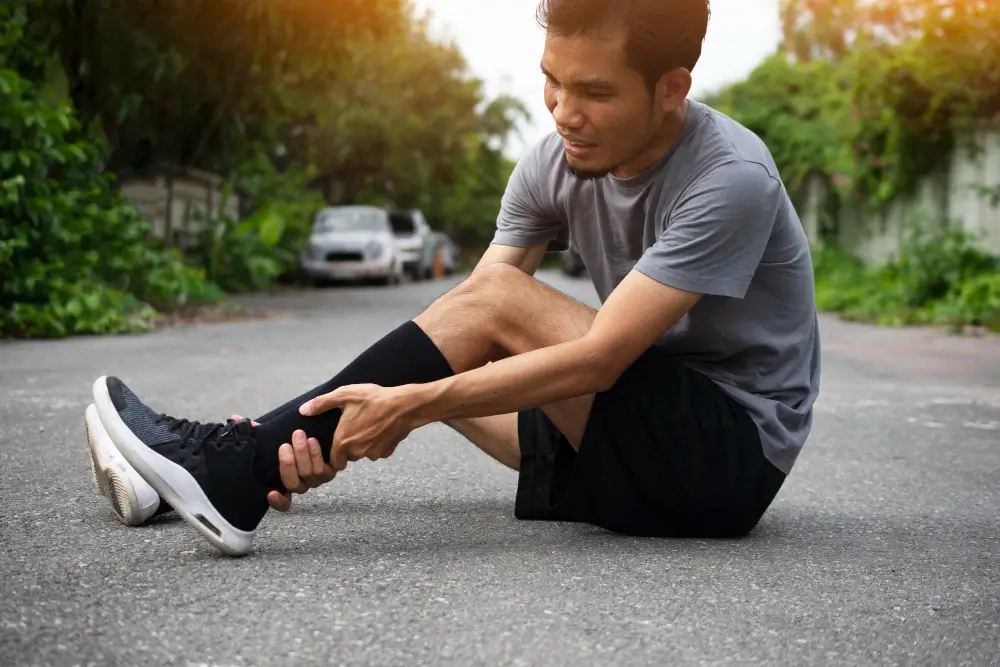 Athlete holding injured ankle after outdoor activity near Lakeside Foot and Ankle Leesburg